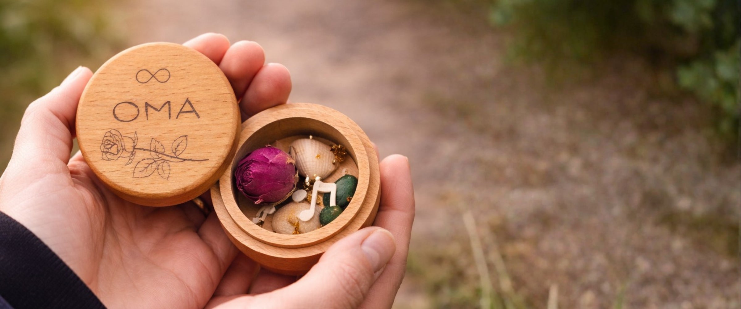 Geöffnete MEMENTOVIA Box mit personalisierter "Lieblingsmensch"-Gravur und symbolischen Trauer-Beigaben.