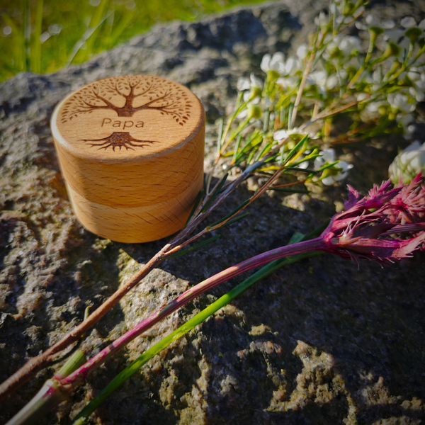 MEMENTOVIA Box auf einem Stein mit Gravur Baum und Schriftzug "Papa" - mit Blumen.